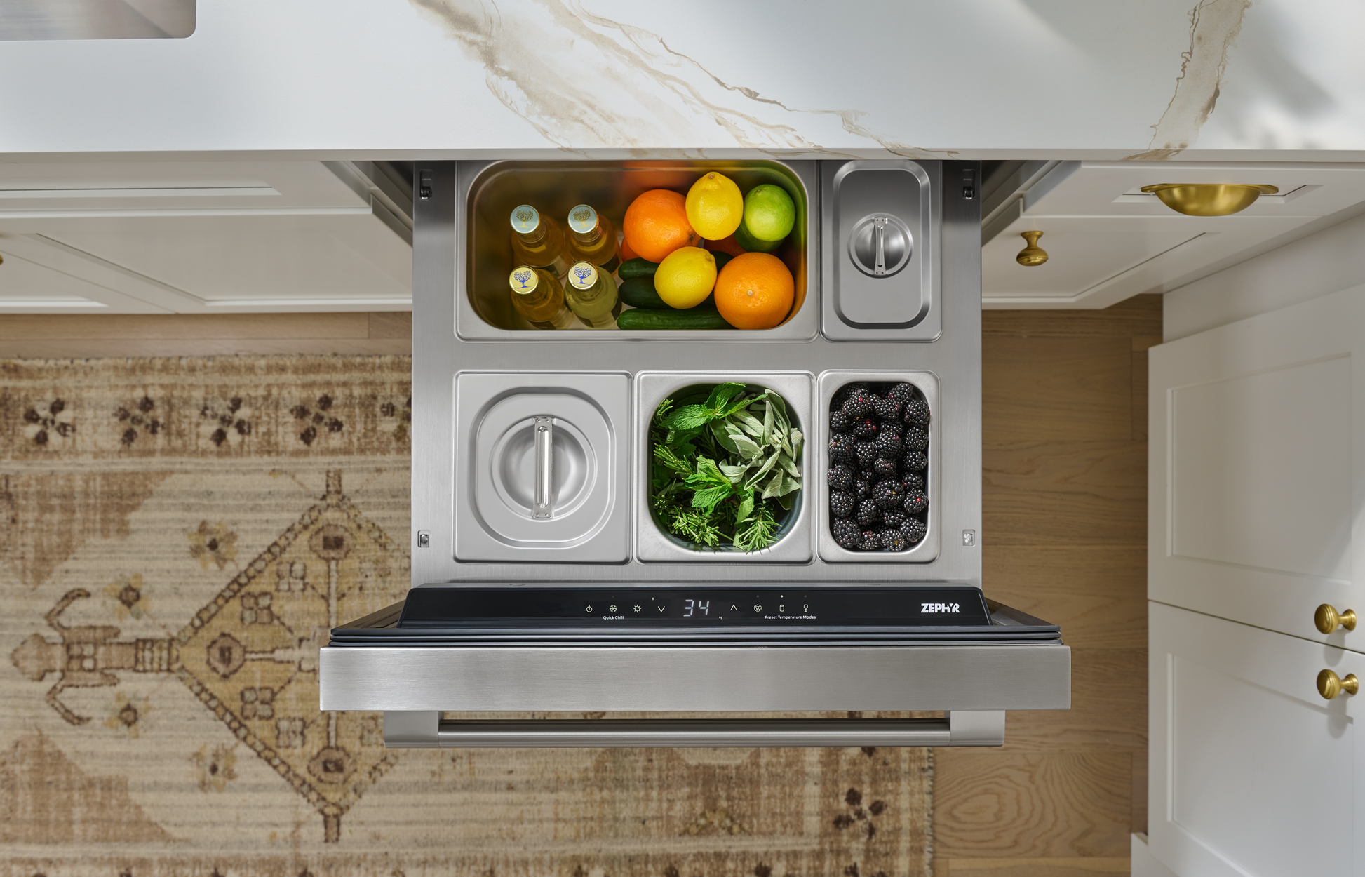 Under-counter stainless steel refrigerator drawer with fresh fruit, herbs, and blackberries in kitchen setting