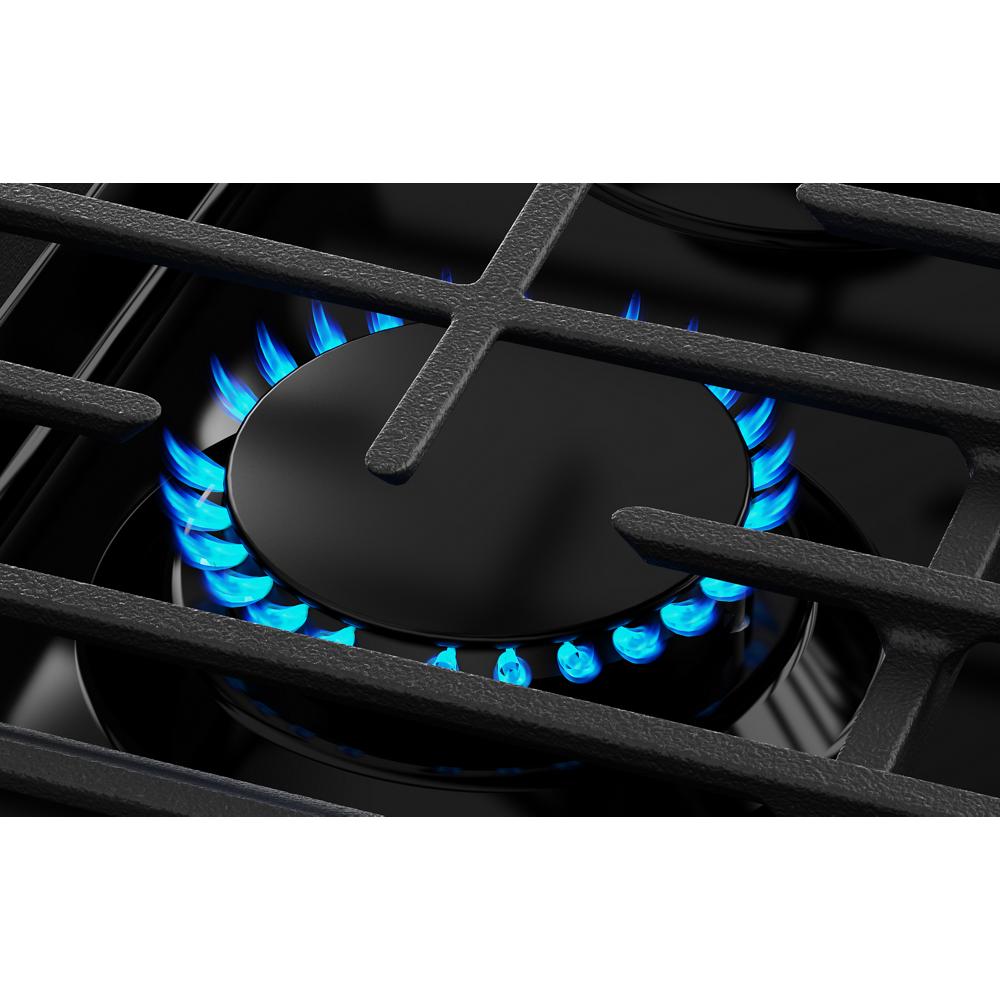 Close-up of a blue gas burner flame under cast iron grates on a black smart slide-in gas range from kitchen appliances collection