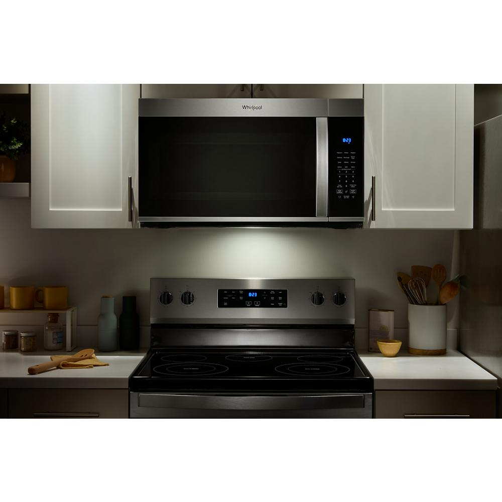 Whirlpool stainless steel over the range microwave with digital controls installed above electric range in modern kitchen setting