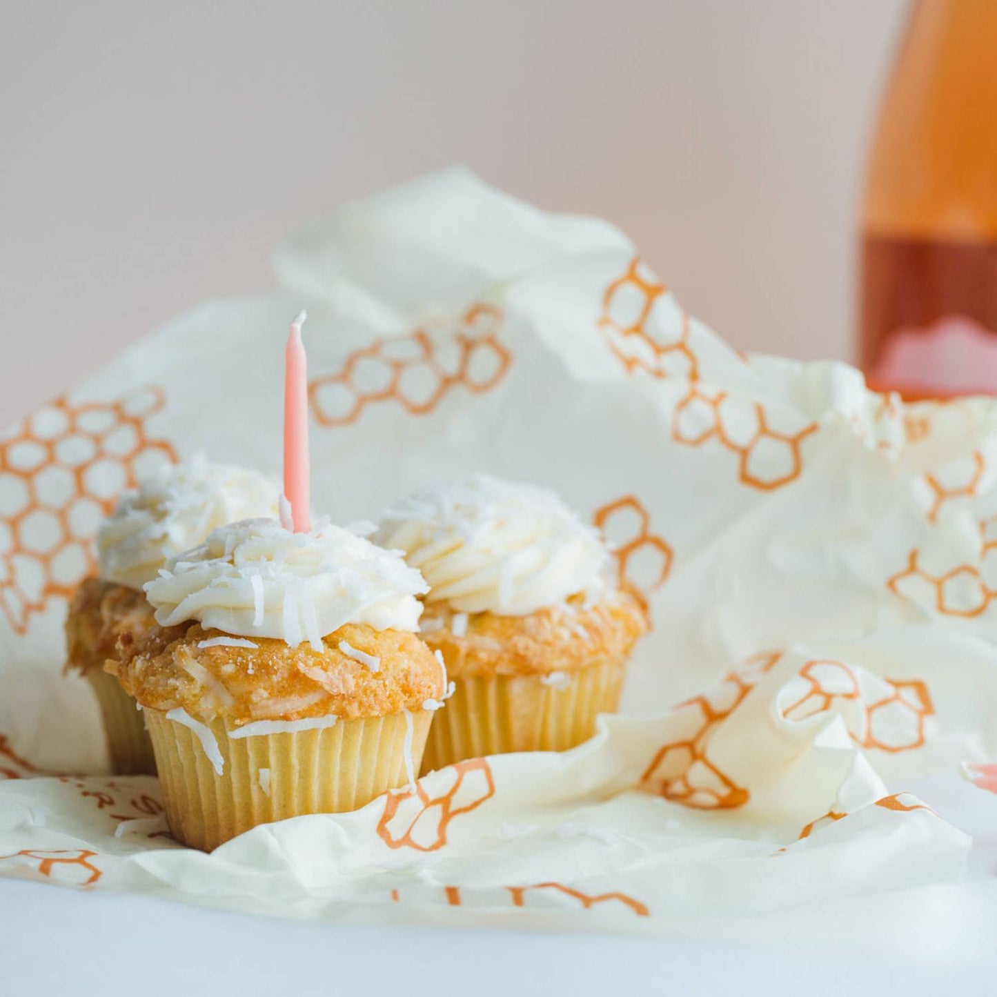 Two cupcakes with white frosting on honeycomb patterned beeswax wrap for kitchen food storage under $50 collections