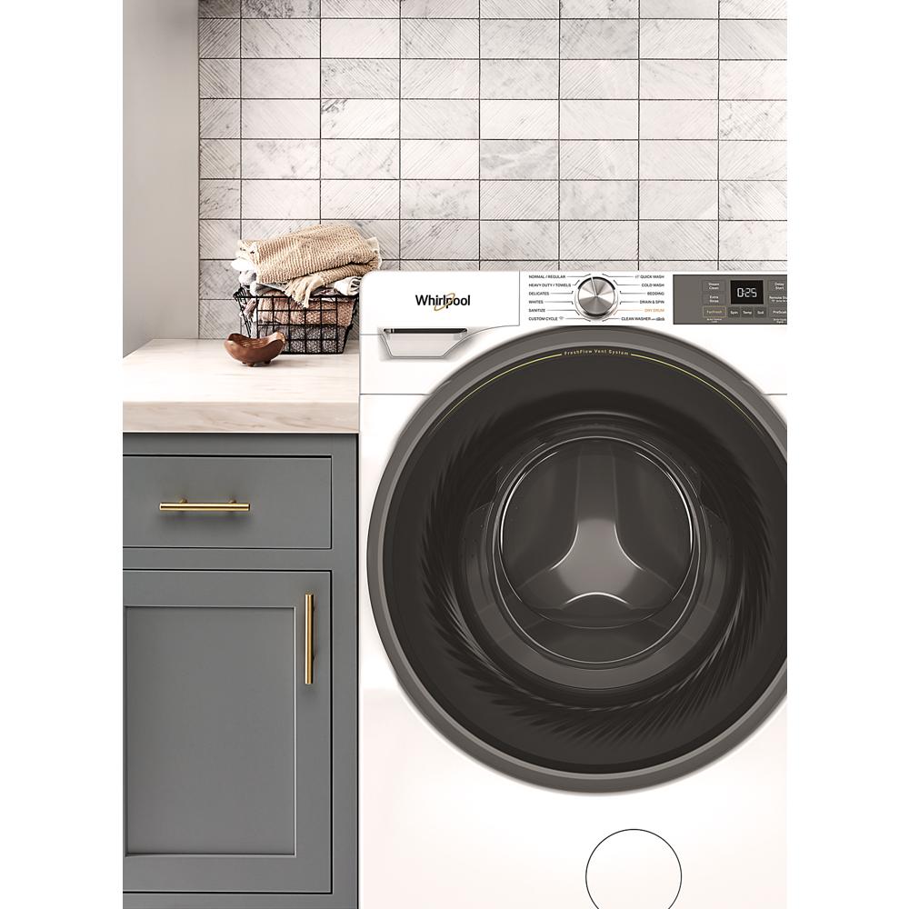 Front load washer with digital display and large black door, integrated in modern laundry space with gray cabinetry and towels.