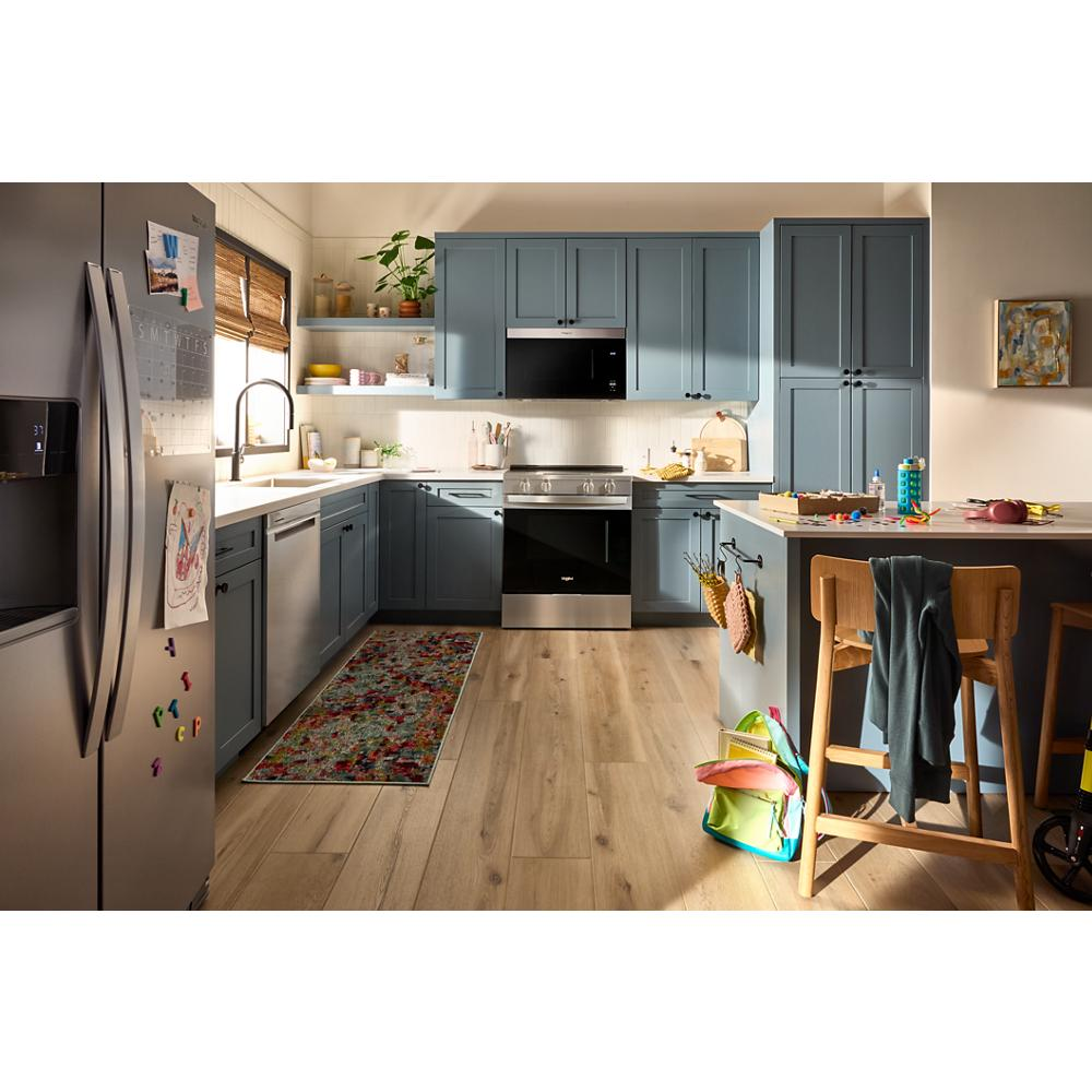 Modern kitchen with built-in black flush mount microwave and matching black glass oven surrounded by blue cabinetry