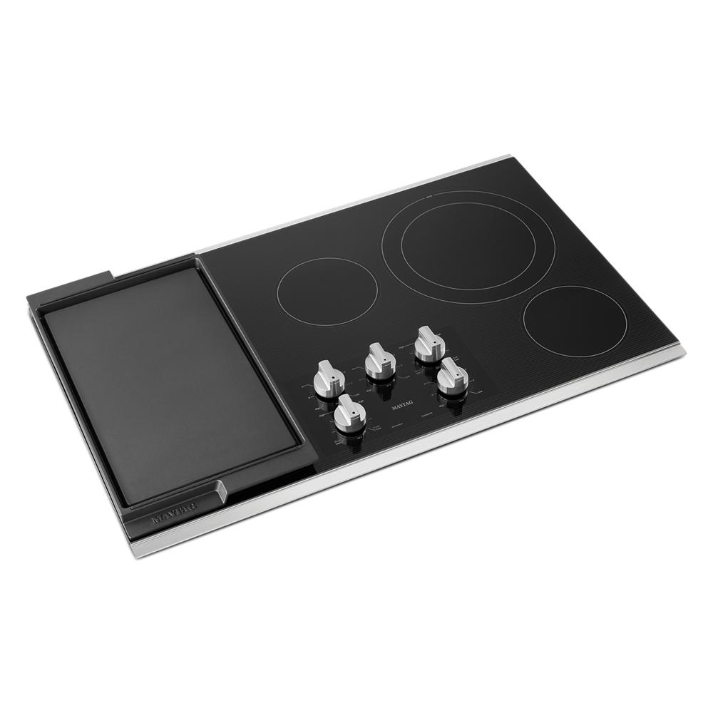 Black electric cooktop with four burners, control knobs, and reversible grill and griddle for kitchen and appliances collections