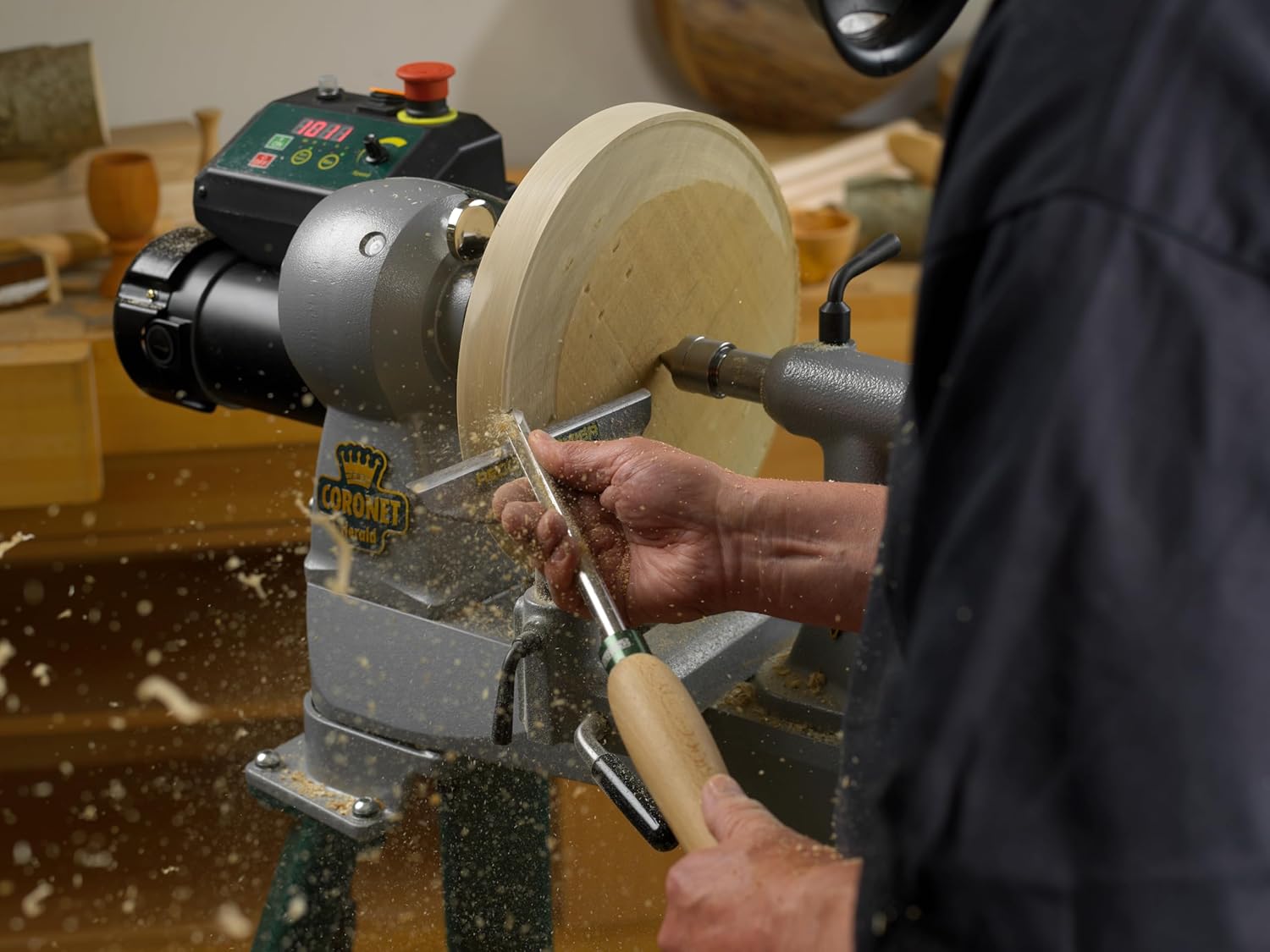 Craftsman shaping wood on lathe using turning tool with 12-inch beech handle in workshop setting