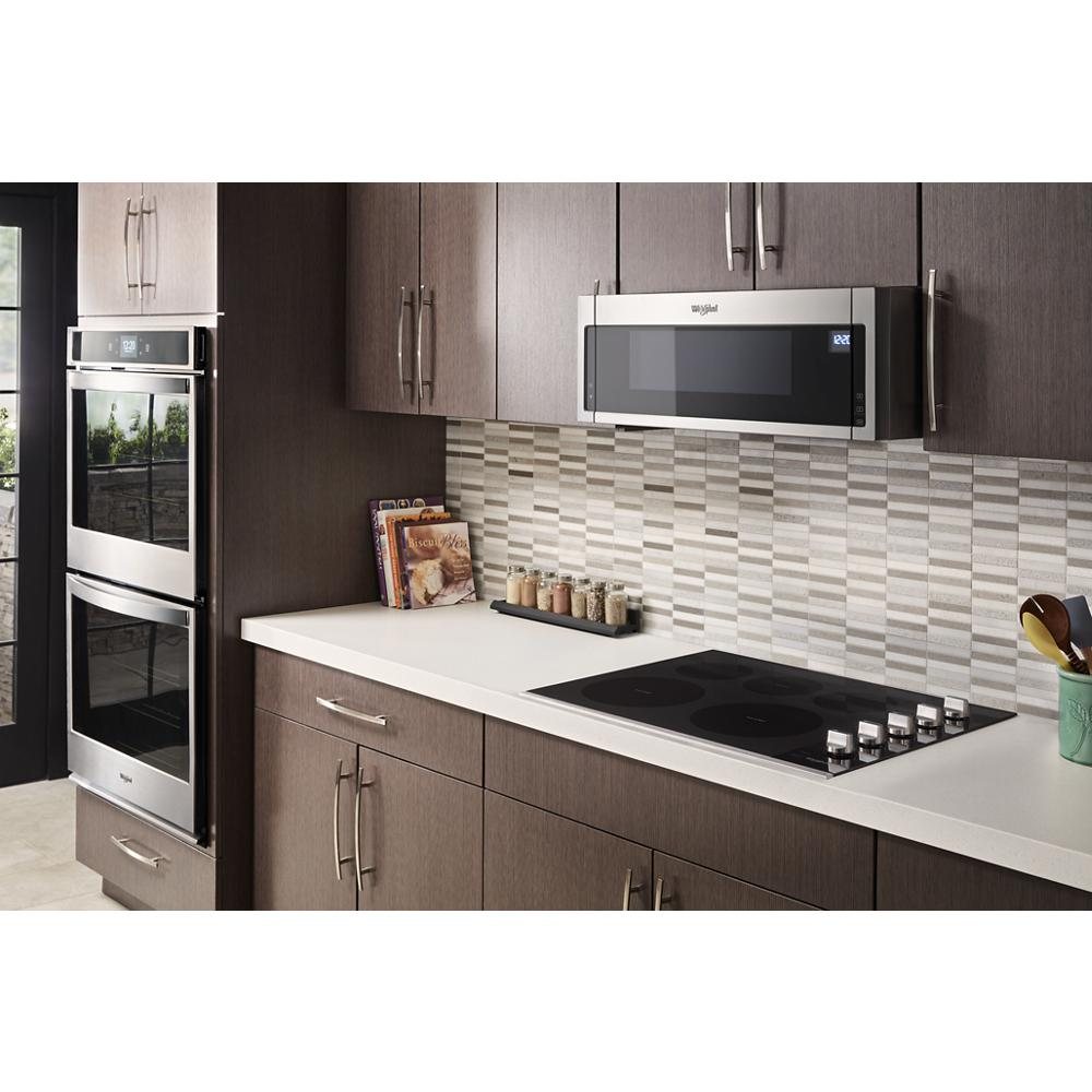 Modern kitchen with dark wood cabinetry, built-in stainless appliances, and electric ceramic glass cooktop with knobs
