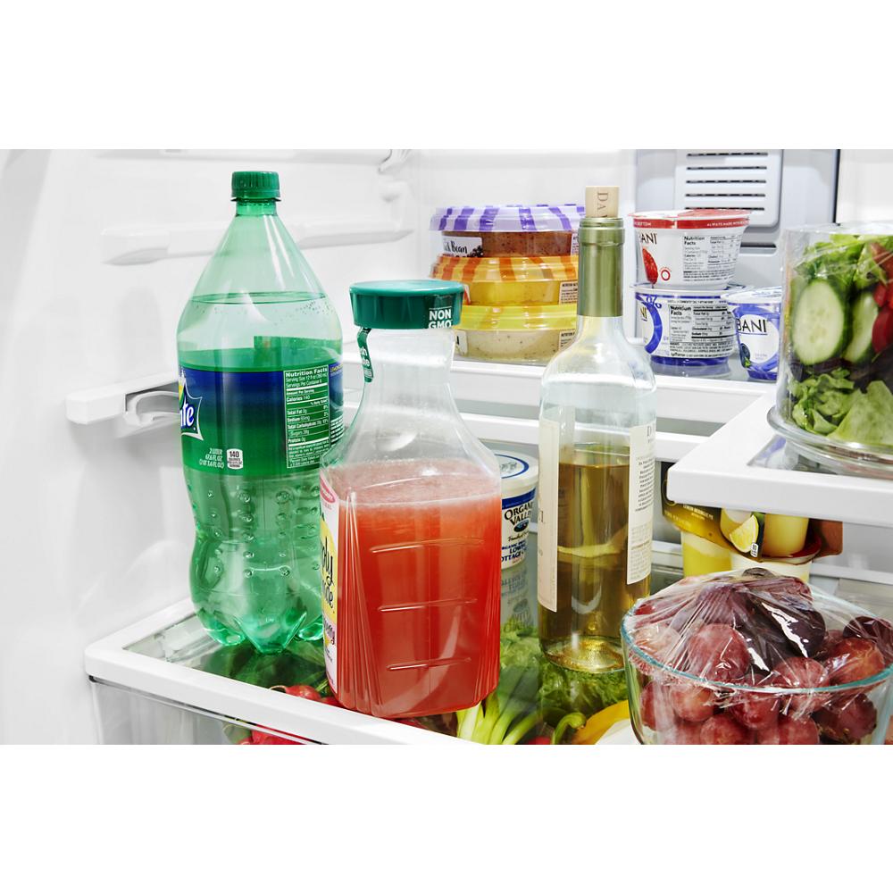 Open interior of a refrigerator filled with beverages, fresh produce, and covered containers from kitchen appliances collection