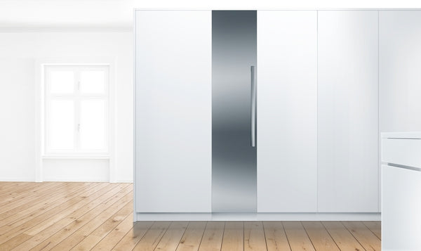 Built-in freezer with flat hinge and stainless steel door panel integrated into modern white cabinetry in kitchen setting