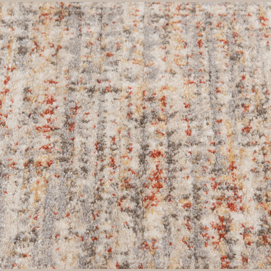 Close-up of textured area rug with cream, rust, blue, yellow, and subtle green tones in home decor collections