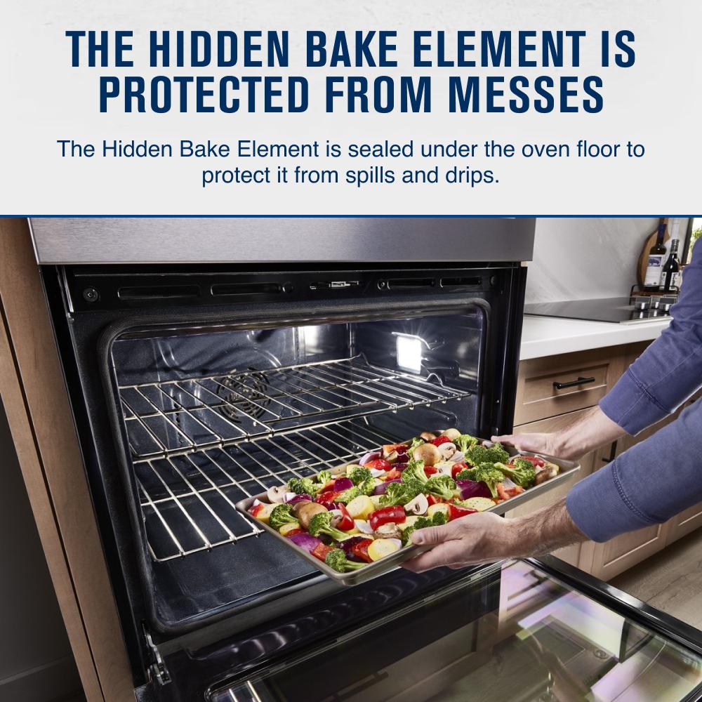 Person placing a vegetable tray inside a stainless steel wall oven with hidden bake element protection in a modern kitchen
