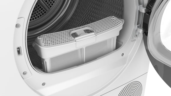 Close-up of a white compact condensation dryer with lint filter compartment inside the open front door in laundry setting