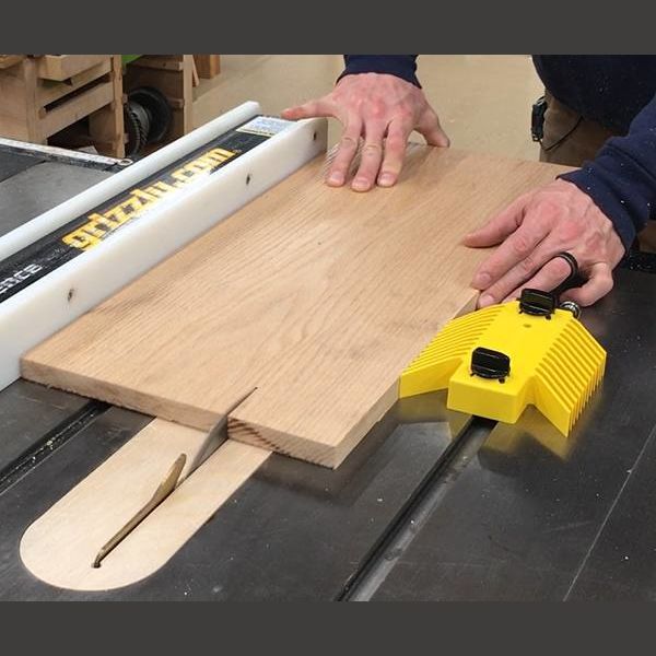 Yellow featherboard securing wood on table saw fence for power tool accessories and saw accessories collection