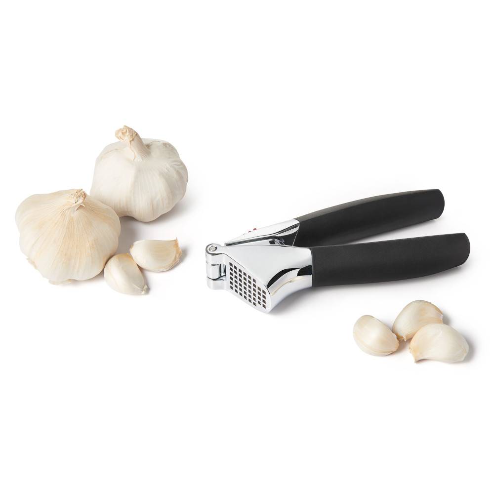 Garlic press with polished metal crushing chamber and soft black handles alongside fresh garlic for kitchenware under $50 collections