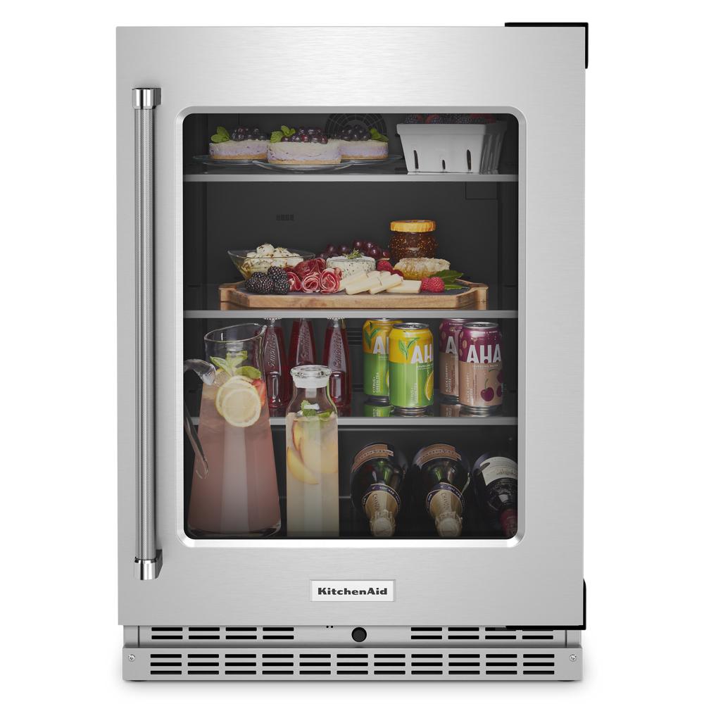Undercounter refrigerator with glass door, metal handle, interior shelves stocked with drinks and snacks in KitchenAid Appliances collection