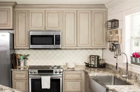 Kitchen with light wood cabinets featuring polished chrome and glass football-shaped knobs in a home improvement setting