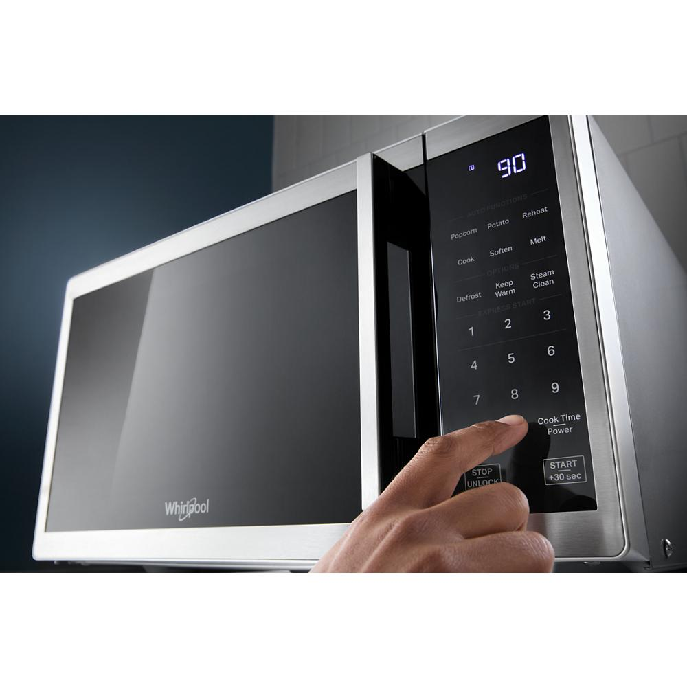 Close-up of stainless steel countertop microwave with digital control panel and white LED display in kitchen appliances collection