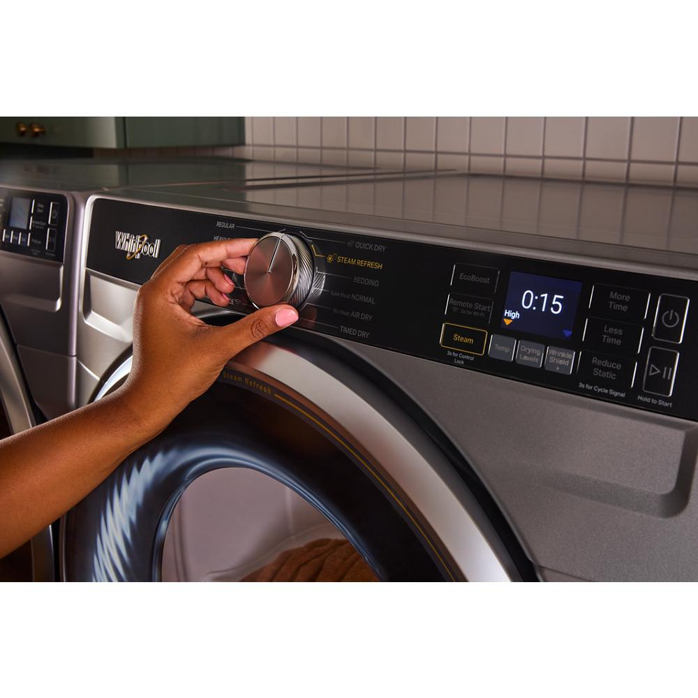 Hand adjusting cycle dial on smart front load gas dryer control panel with digital display and steam option