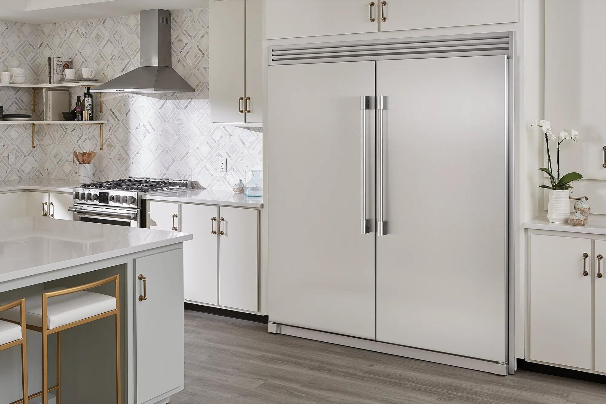 Built-in stainless steel double-door freezer in a modern kitchen setting with white cabinetry and hardwood floors