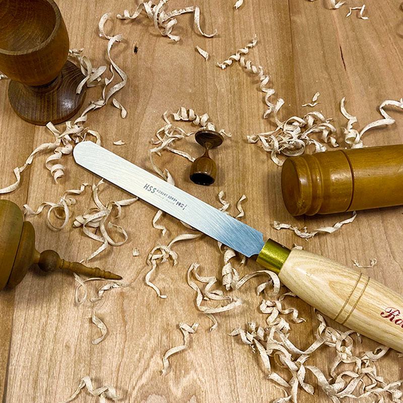 Woodturning tool with high-speed steel blade and wooden handle surrounded by wood shavings in woodworking tools collection under $100