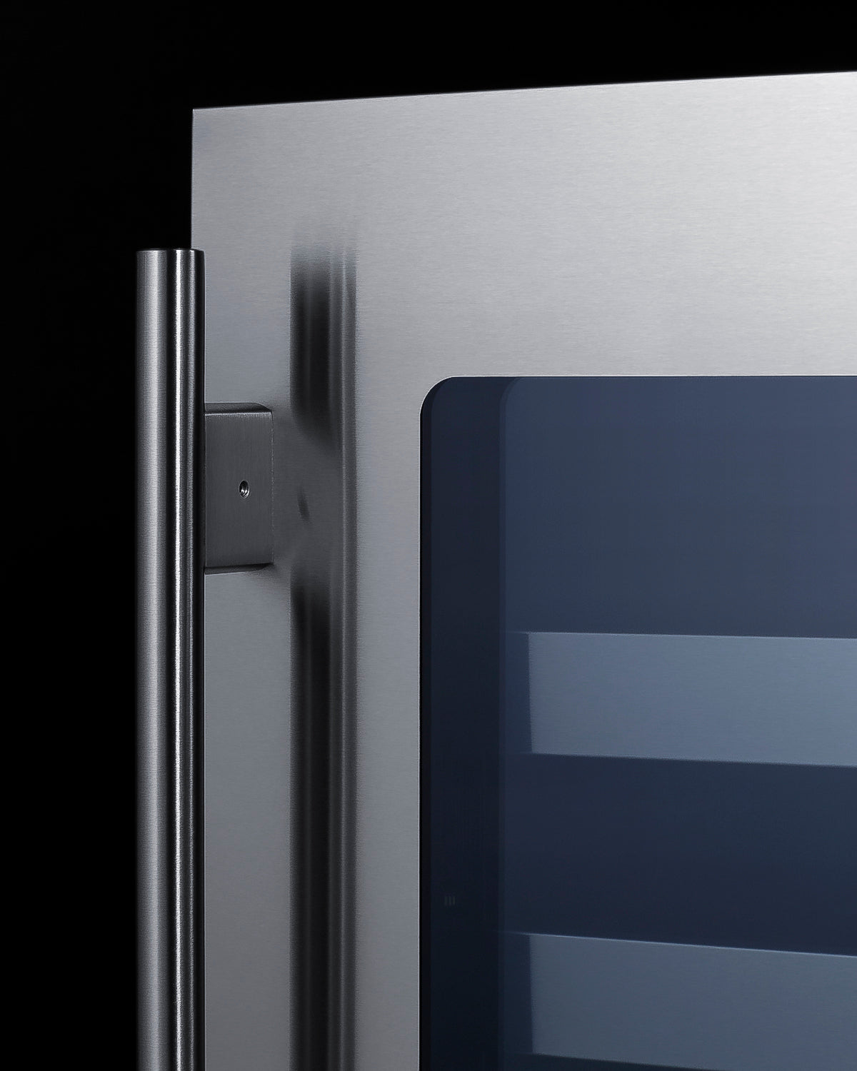 Close-up of stainless steel wine cellar door with vertical handle and tinted glass panel for beverage center appliances.