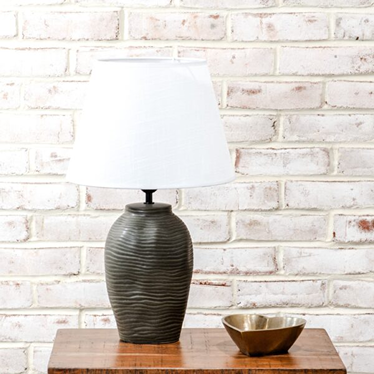 Table lamp with a matte black textured base and white fabric shade for home and garden decor.