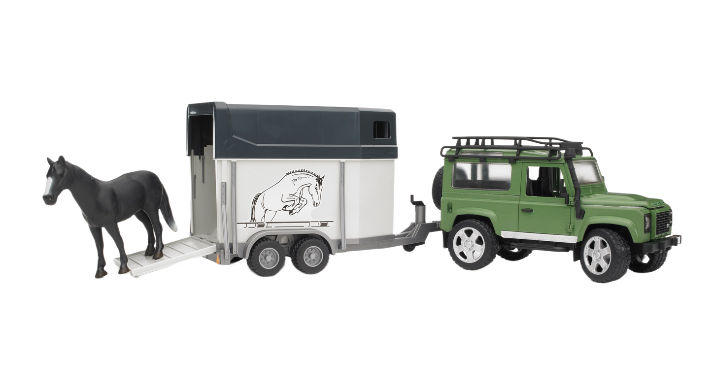 Green toy Land Rover Defender pulling a white and black horse trailer with a black horse figure on the lowered ramp