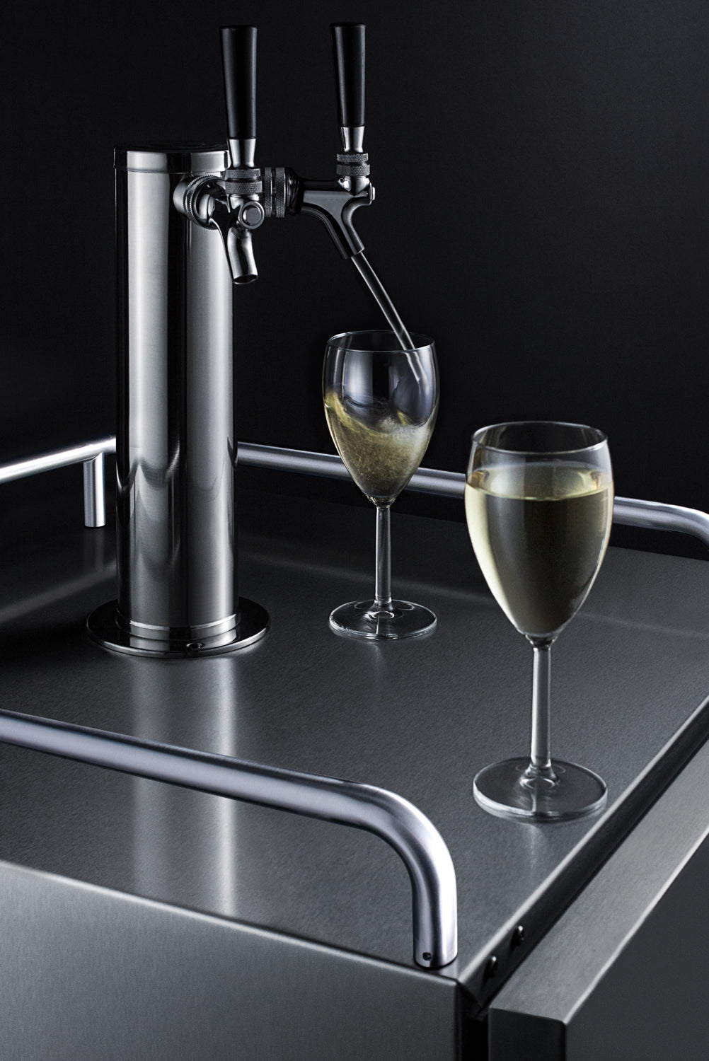 Sleek stainless steel dual tap wine dispenser pouring into glass with second glass nearby on stainless surface in beverage centers collection