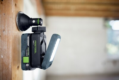 Black magnetic adapter base with adjustable mount holding Festool Syslite on wooden beam in tool accessories collection