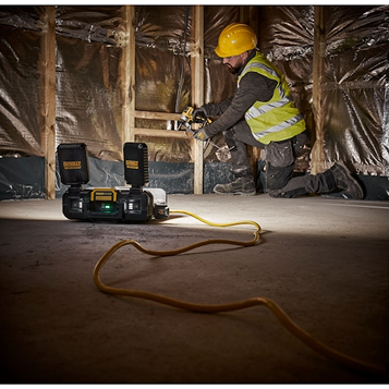 DEWALT Toughsystem work light with dual LED heads illuminating worker installing insulation in home improvement setting