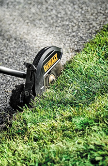 DEWALT edging attachment cutting grass along pavement edge in outdoor home improvement and Dewalt collections
