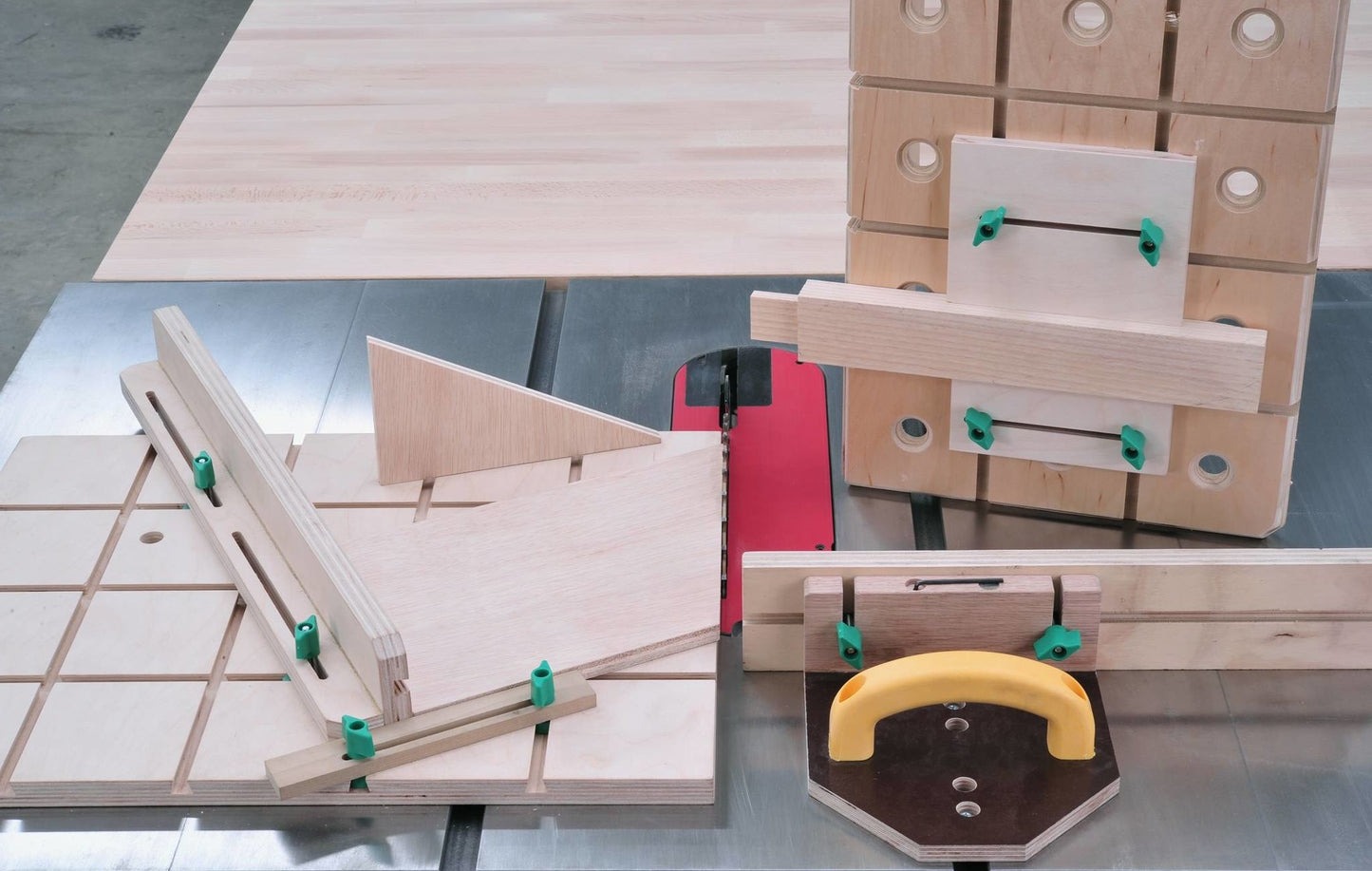 Woodworking jig setup with wooden guides and green dovetail hardware clamps on saw table in tools collection