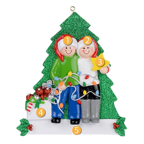 Personalized couple figurine decorating in front of glittery green tree with holiday lights and gift from Christmas collection