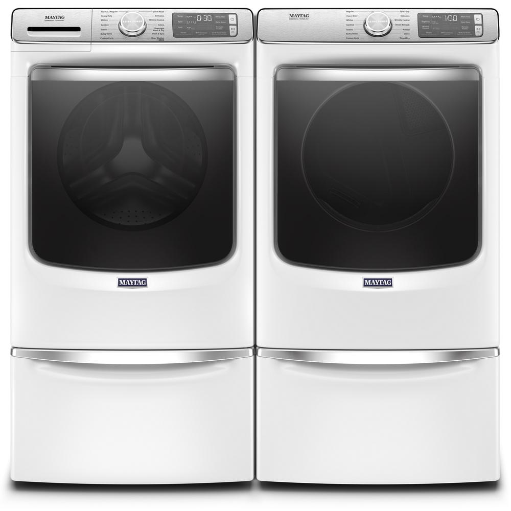 Front view of matching white Maytag front load washer and electric dryer with digital displays and control knobs in appliance collection