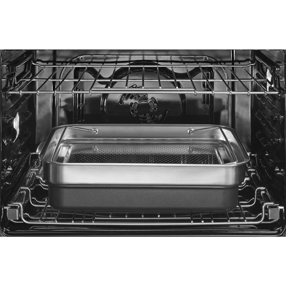 Interior view of double wall oven showing stainless steel baking pan on lower rack with metal oven racks above