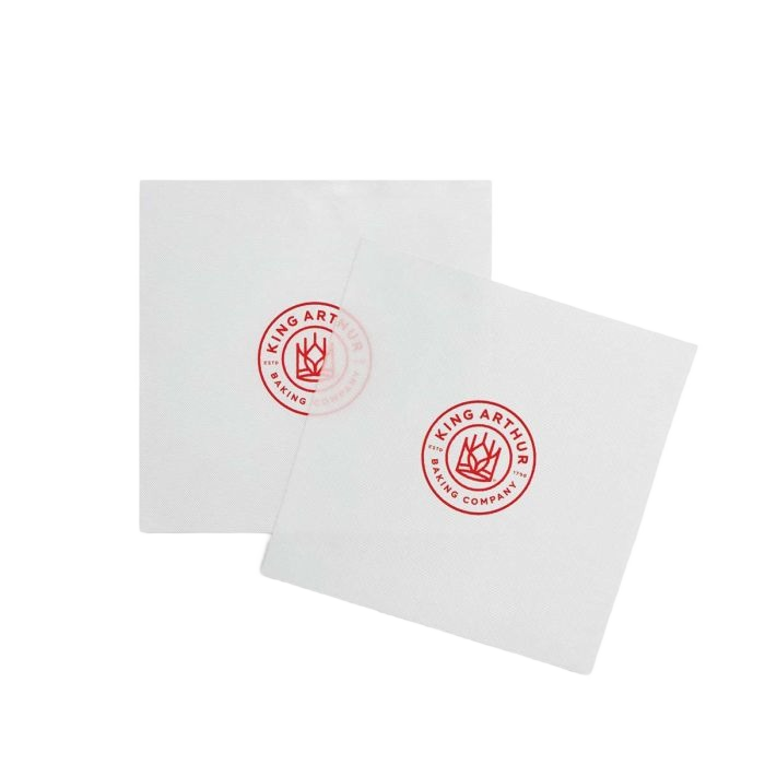 Two white square cake pan liners featuring a red King Arthur Baking Company logo in the center.