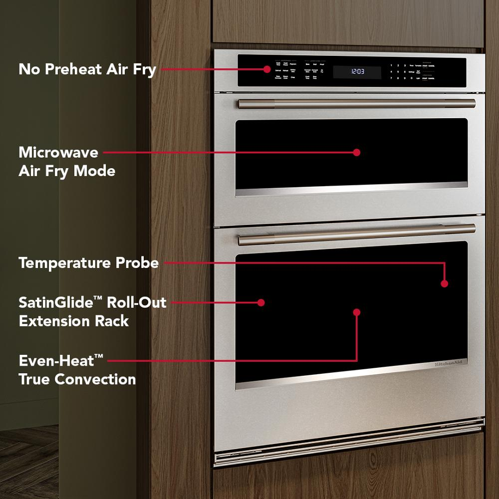 Built-in stainless steel double wall oven with digital display and labeled features in modern wooden kitchen cabinetry