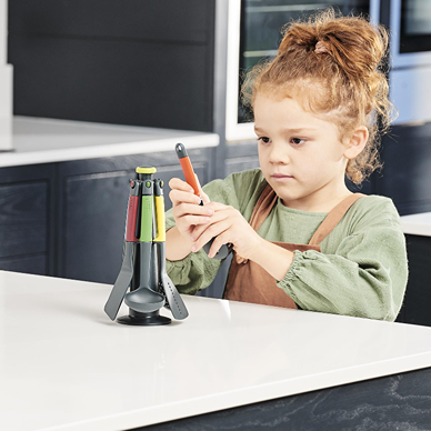 Child playing with colorful kitchen utensil set on a stand designed for learning and imaginative play