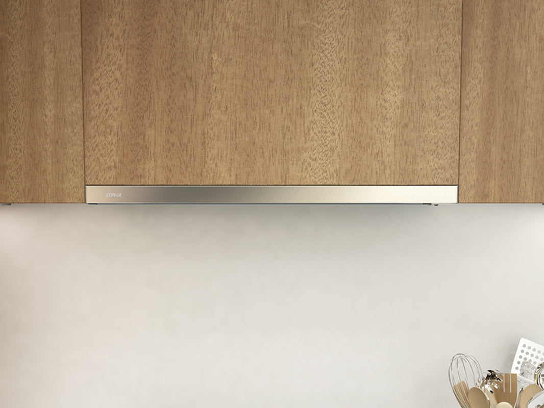 Under-cabinet range hood with white and glass design blending seamlessly with wood cabinetry from Over the Range Hoods collection