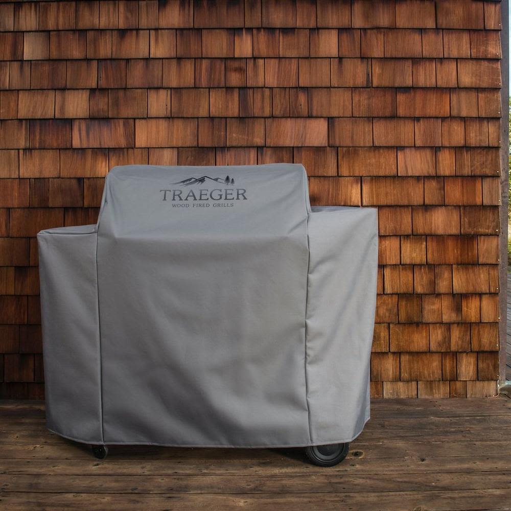 Gray full-length weather-resistant grill cover with Traeger branding for outdoor grilling and lawn care accessories