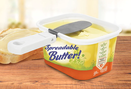Collapsible white-handled tub butter knife clipped to a yellow plastic spreadable butter container in kitchenware collection