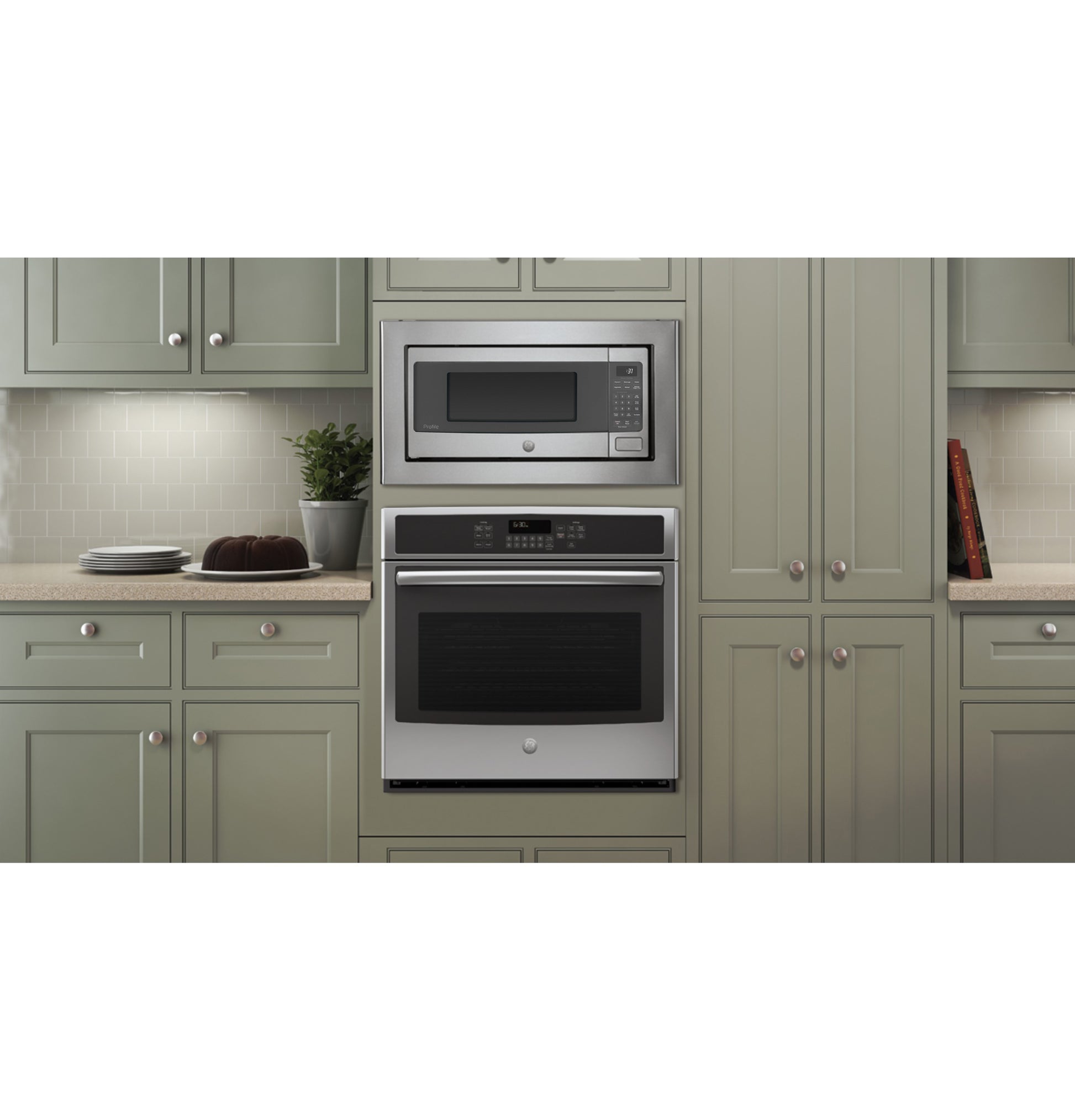 Built-in stainless steel microwave oven above matching wall oven in gray kitchen cabinetry from appliances collection