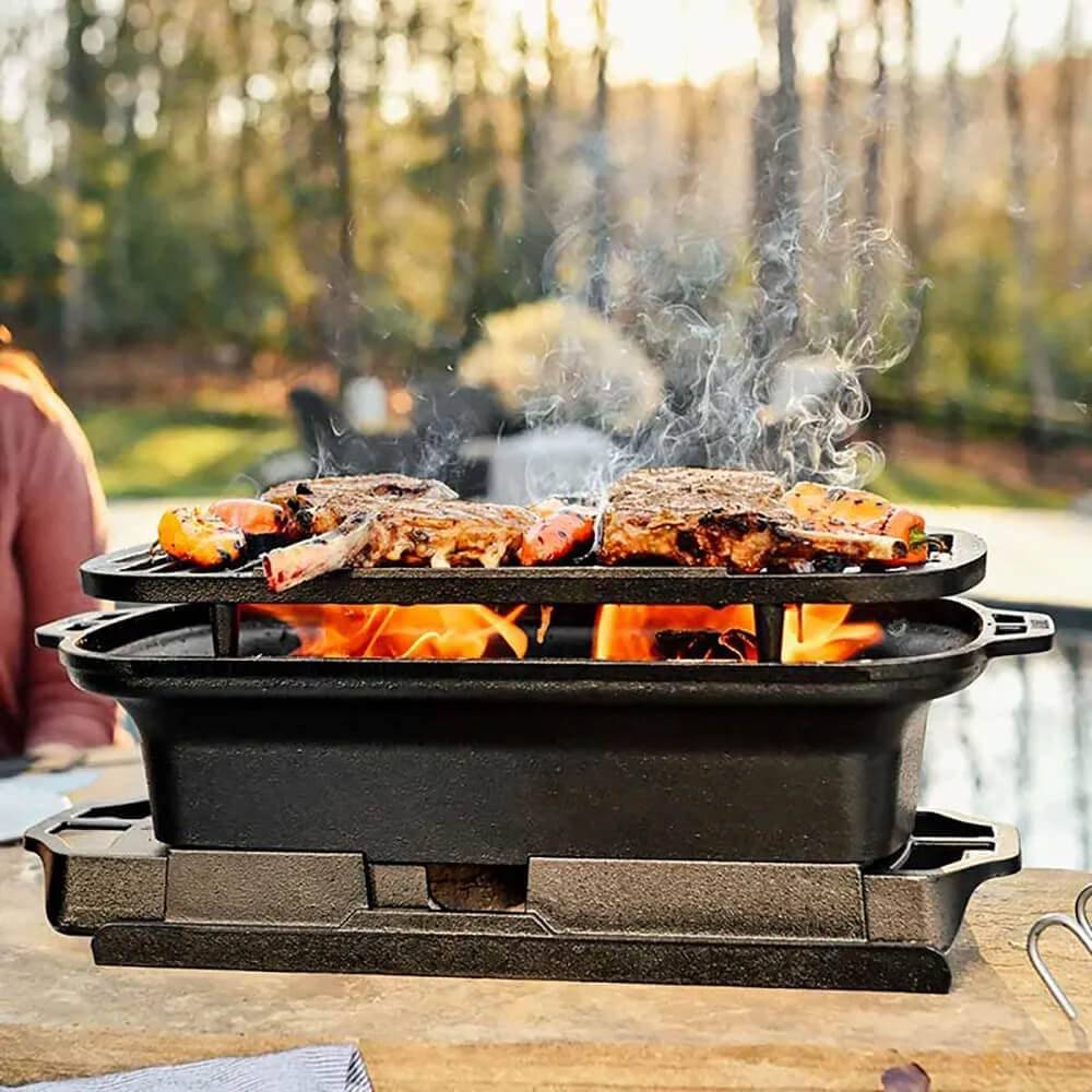 Elevated cast iron grill with handles and grilling surface over an open flame, part of kitchenware collections