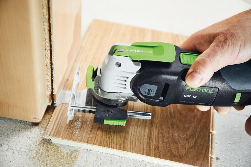 Festool OSC 18 cordless multi-tool with adjustable depth stop cutting precision wood panel on concrete surface