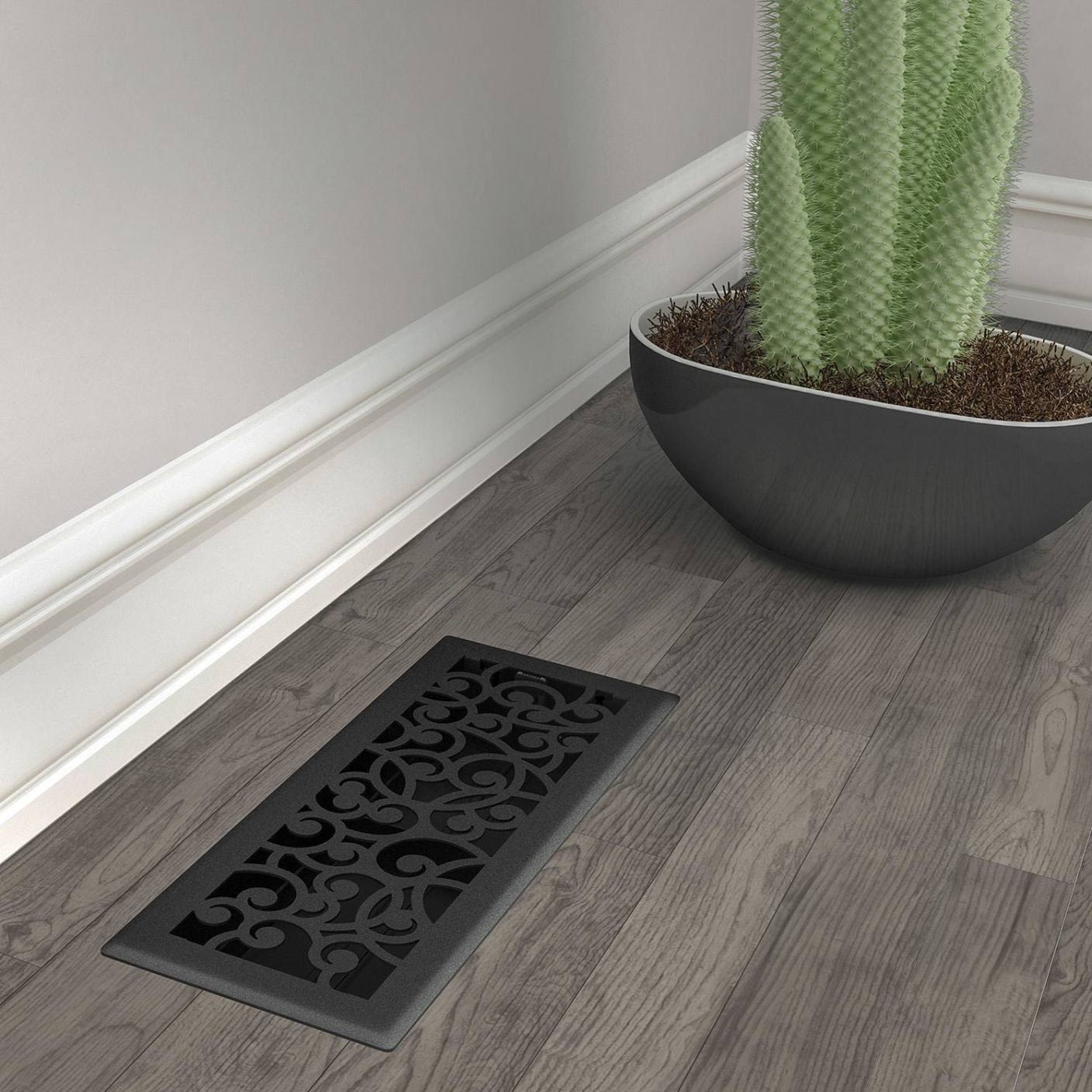 Black iron floor vent register with decorative scroll pattern installed on wood flooring for home improvement under $50 collection