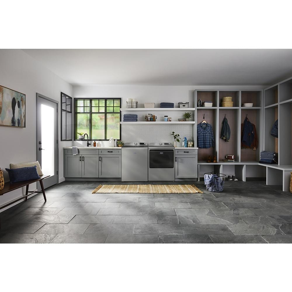 Modern laundry room featuring gray cabinetry, stainless steel washer and dryer, and open storage closets with seating bench
