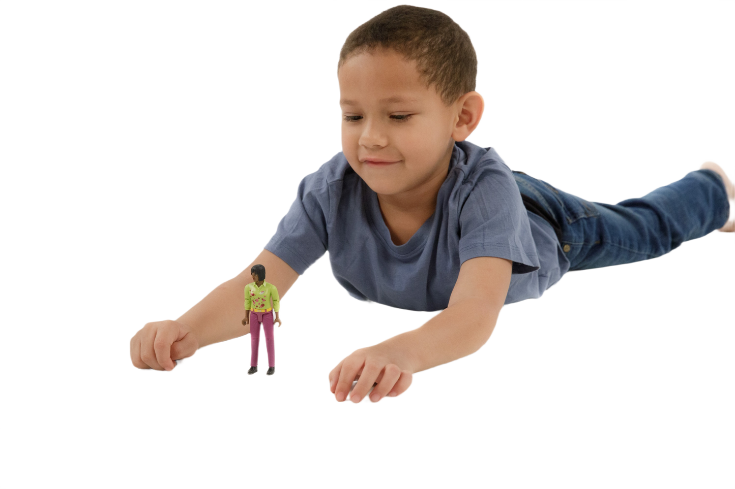 Child lying down playing with a medium skin tone toy woman figure wearing a green top and pink jeans