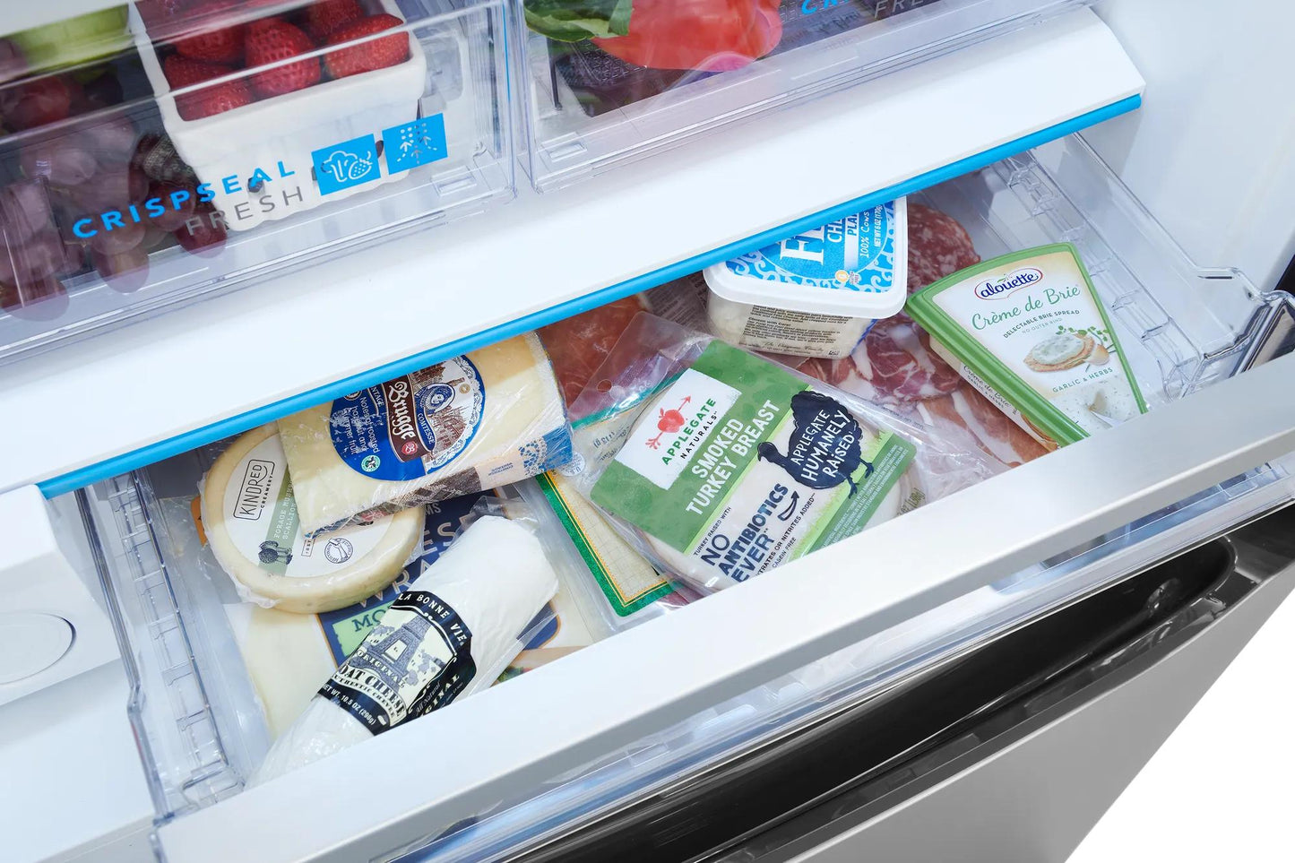 Open refrigerator drawer with various packaged cheeses showcasing organized fresh food storage in kitchen appliance setting