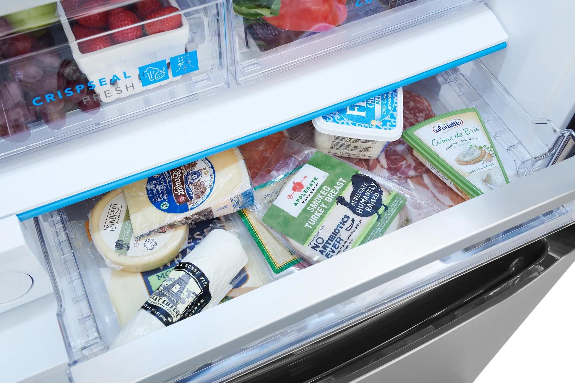 Open refrigerator drawer with various packaged cheeses showcasing organized fresh food storage in kitchen appliance setting
