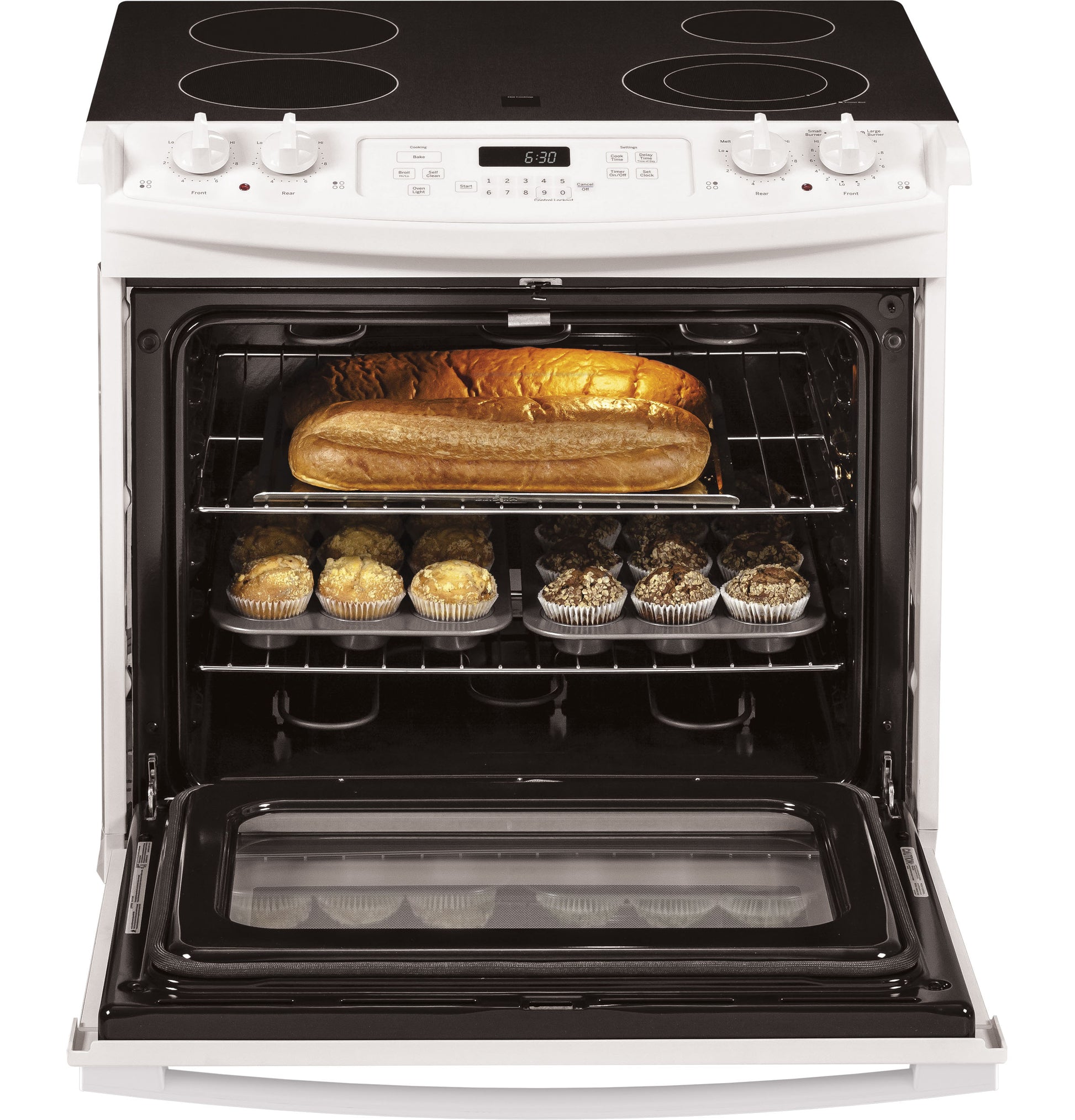 White drop-in electric range with smooth cooktop and open oven containing bread loaf and muffins in kitchen appliances collection