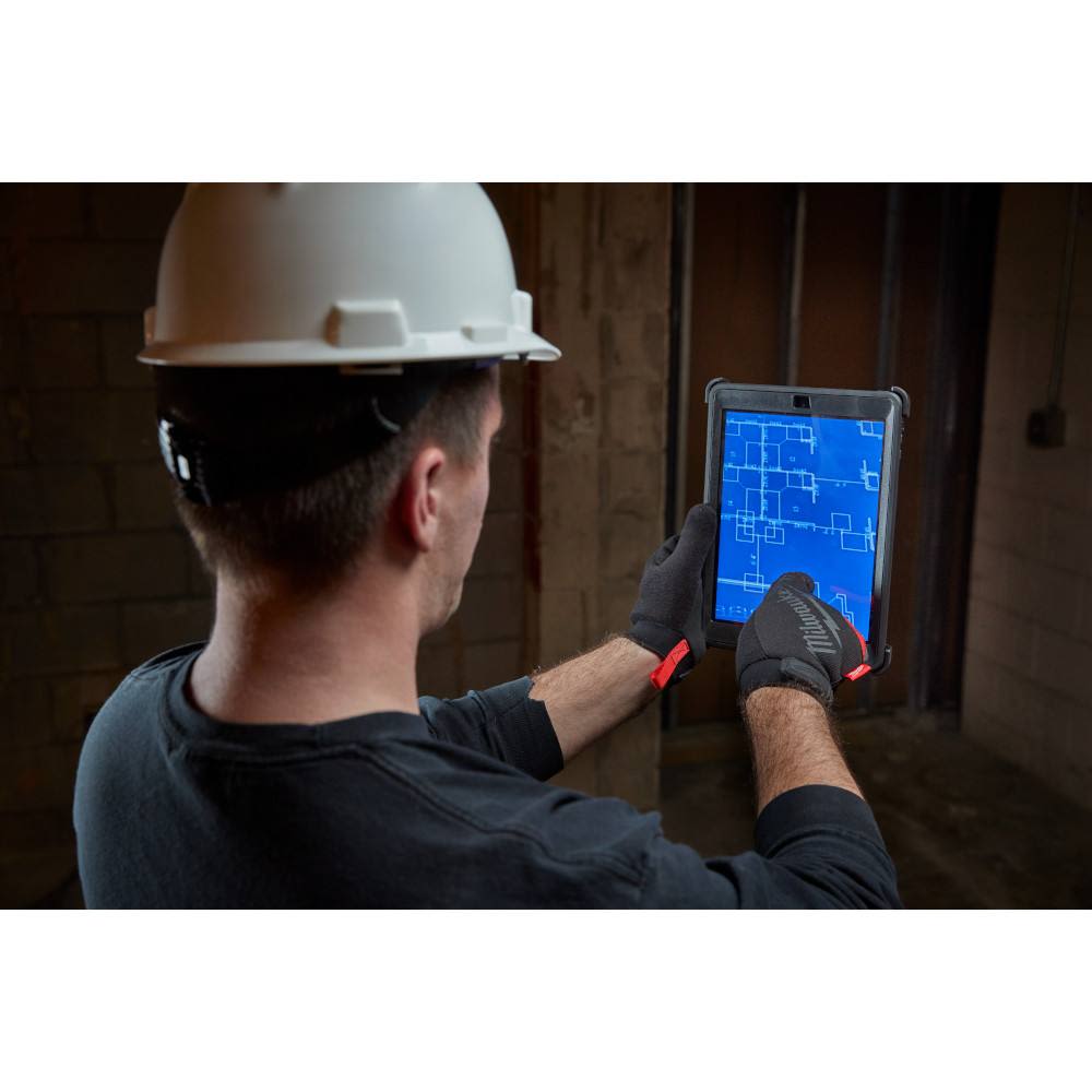 Worker wearing large black and red performance gloves using touchscreen tablet in safety and hardware collections