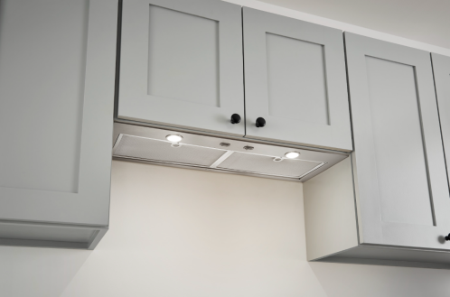 under-cabinet stainless steel power pack insert with LED lighting in modern kitchen range hood setup
